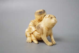 A Japanese ivory netsuke of a boy and puppy, Meiji period, unsigned, 4cm